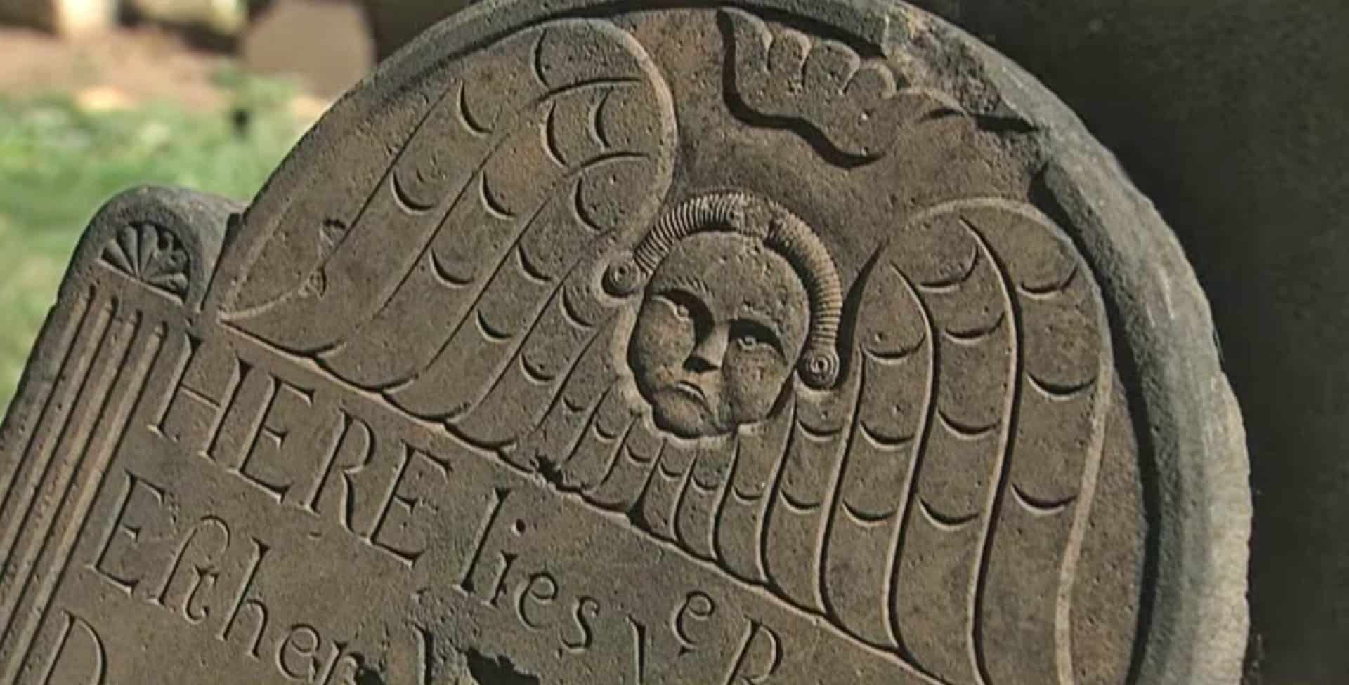 Close up of a Victorian-era gravestone with an angel carving