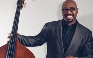 Bassist Christian McBride smiles with his bass